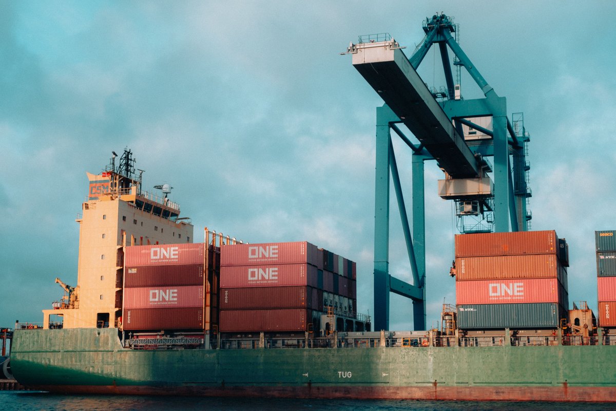 Container ship loaded with colorful ocean containers at a busy port
