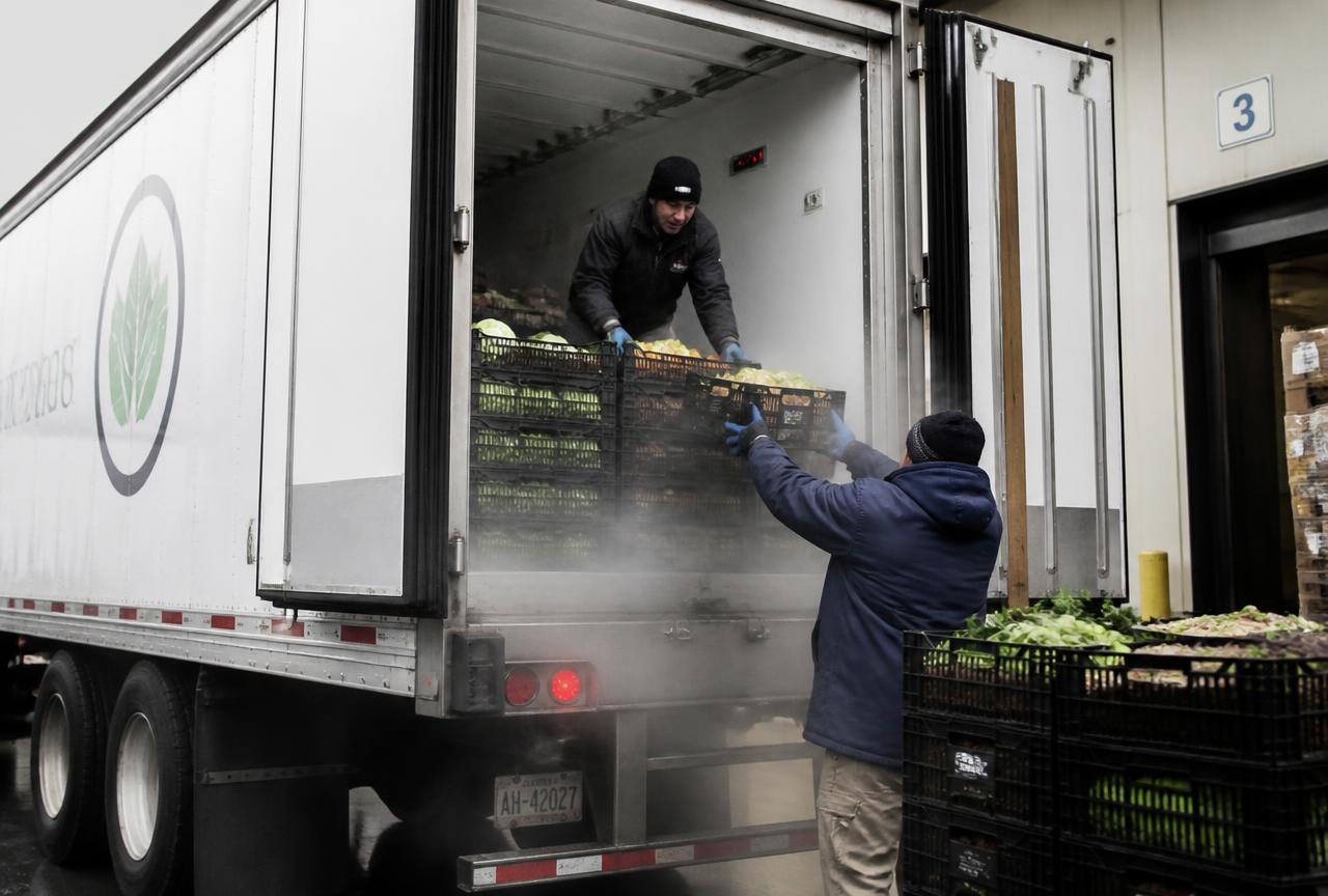 Refrigerated trailer being loaded with crates of fresh produce